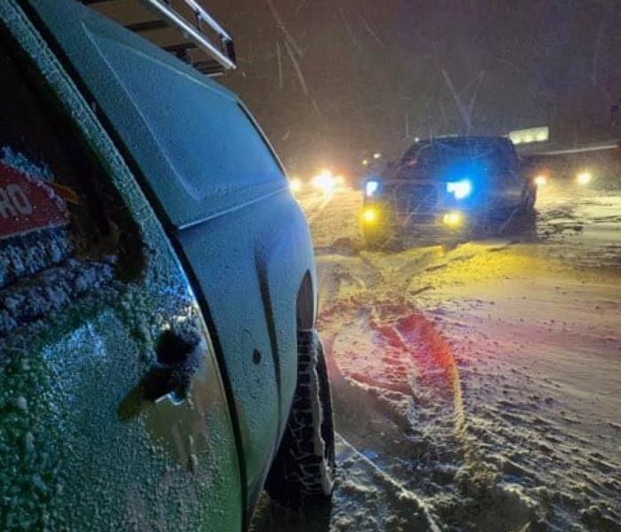 SERVPRO vehicle helping a car stuck in the snow